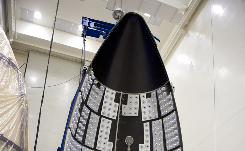 In the Payload Hazardous Servicing Facility at NASA's Kennedy Space Center in Florida, a section of the Atlas V payload fairing for NASA's Mars Science Laboratory (MSL) mission hangs vertically from the ceiling.